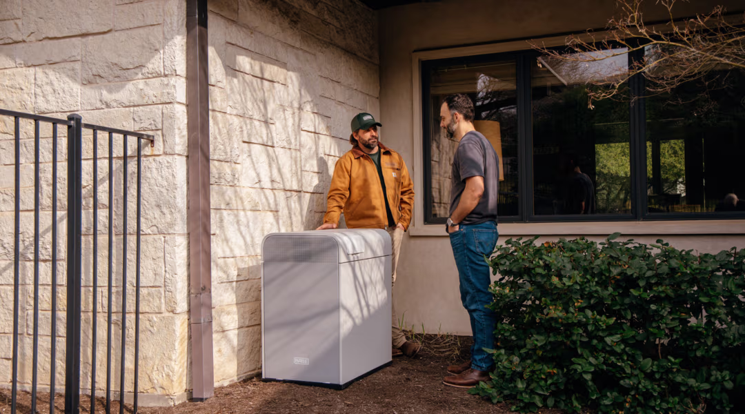 A Base customer talking with a Base team member beside their Base Core battery