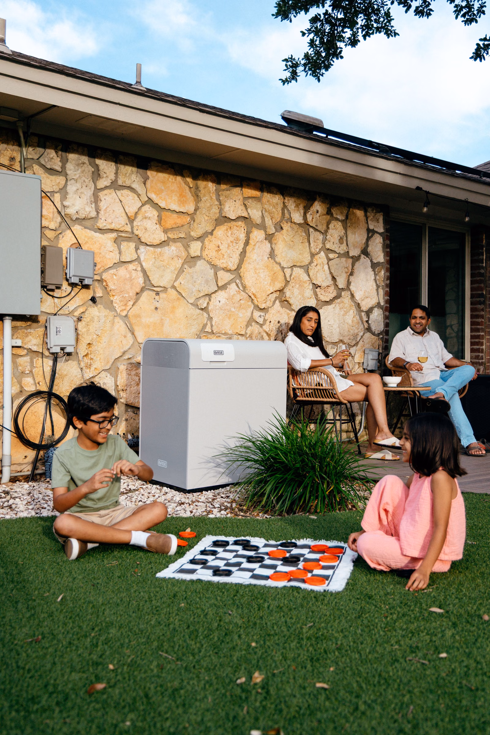 A family playing in the backyard beside their Base Core