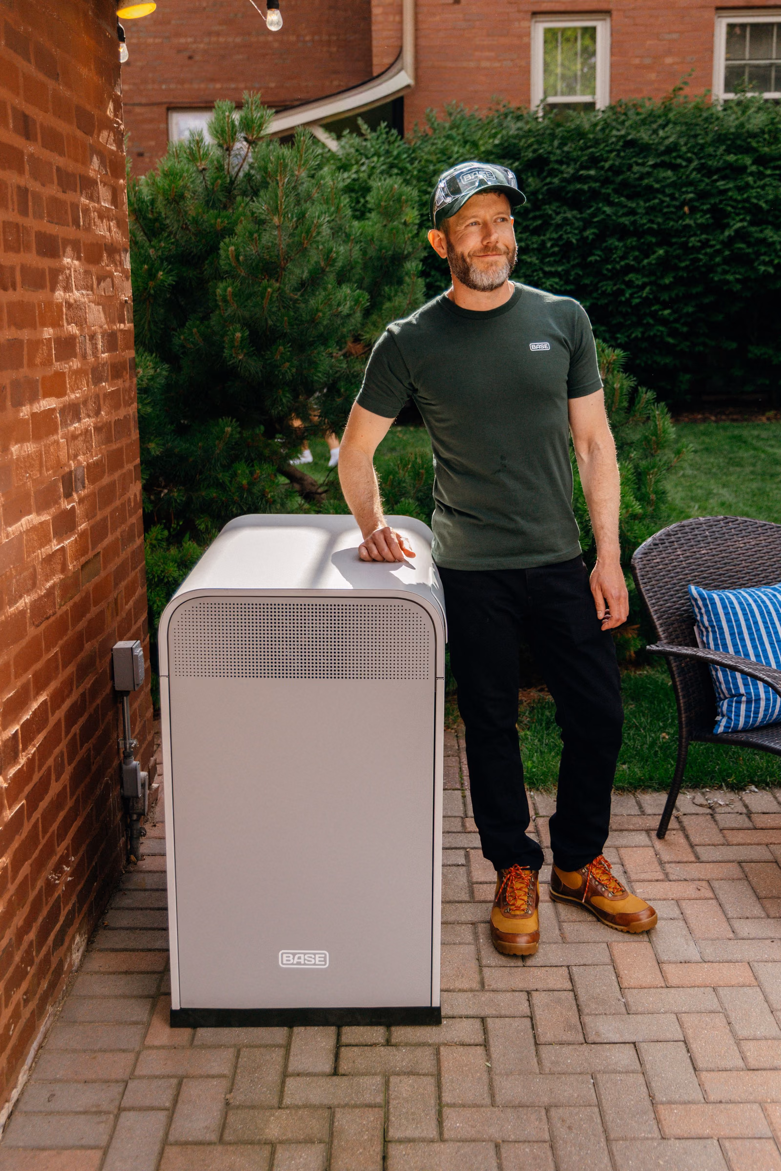 A person standing beside a Base Core on a back patio