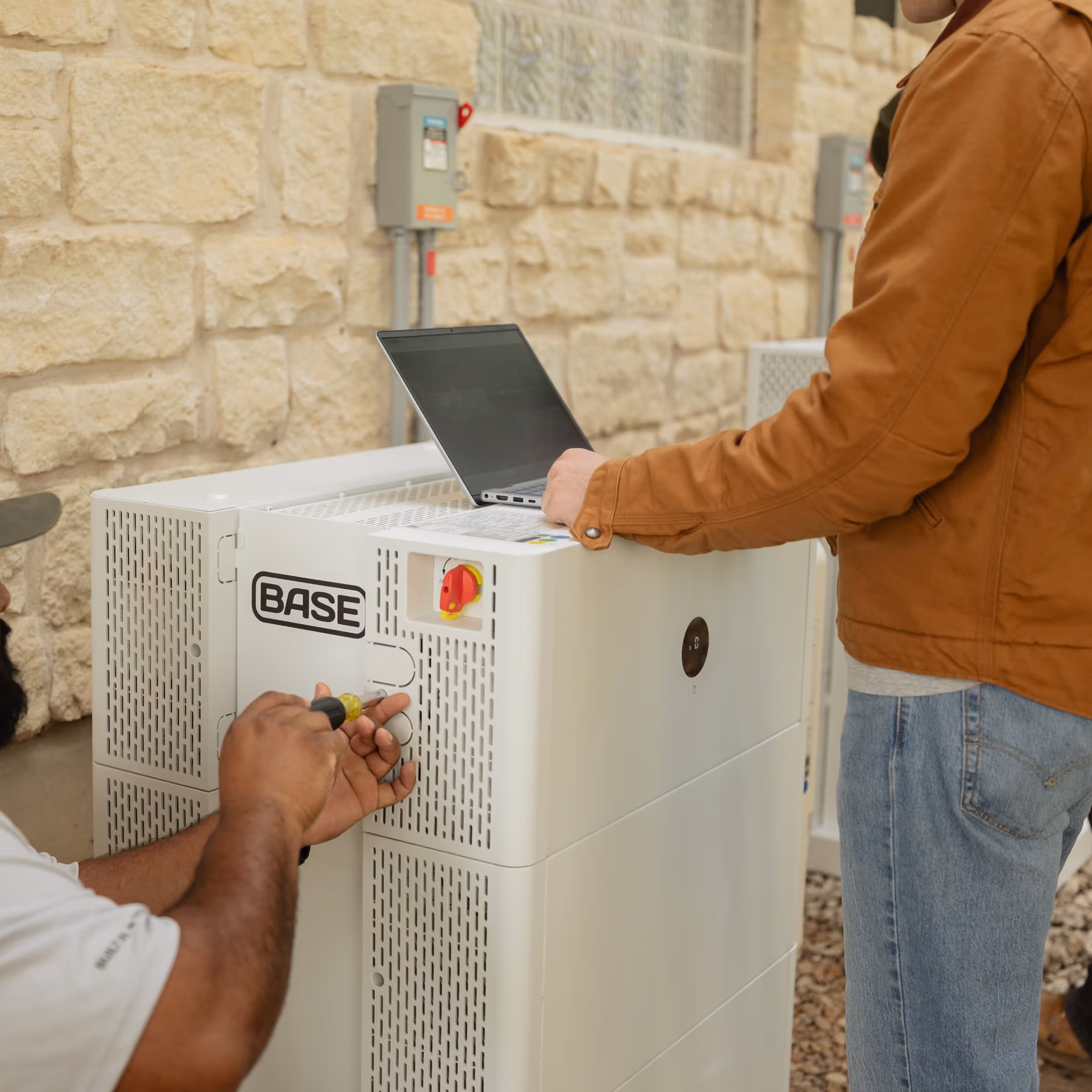 A Base home battery installed beside a house.