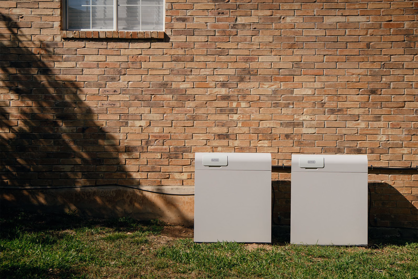 Two Base whole-home backup batteries installed beside a Texas home