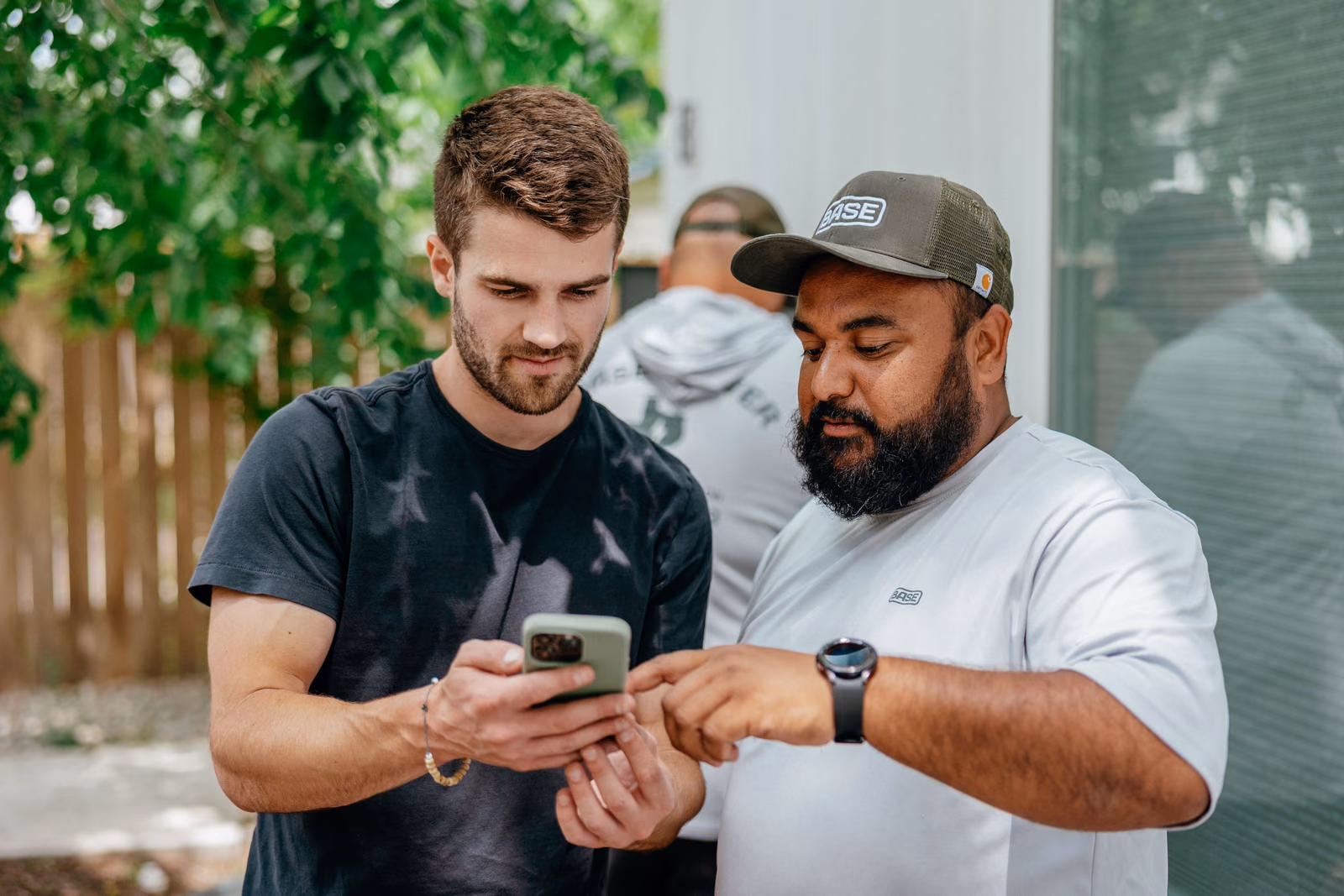 A Base team member and a homeowner looking at a phone together