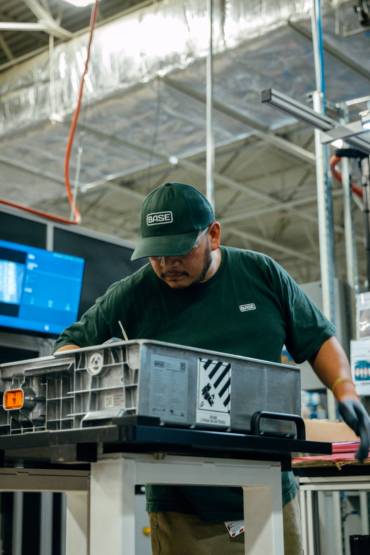 A Base technician working on a battery module on the factory floor
